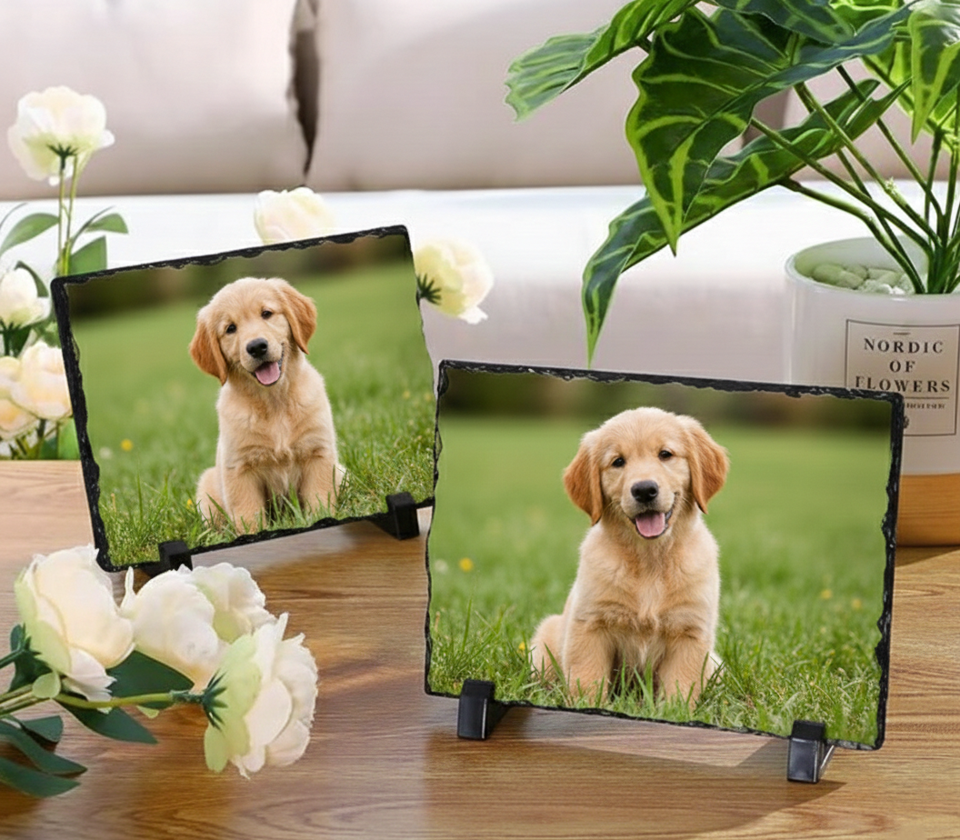 Two slate platters with images of a golden puppy on a grassy background, surrounded by flowers and plants.