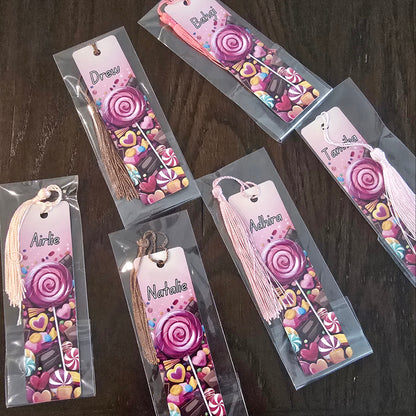 Decorative bookmarks with colorful designs and tassels on a dark surface