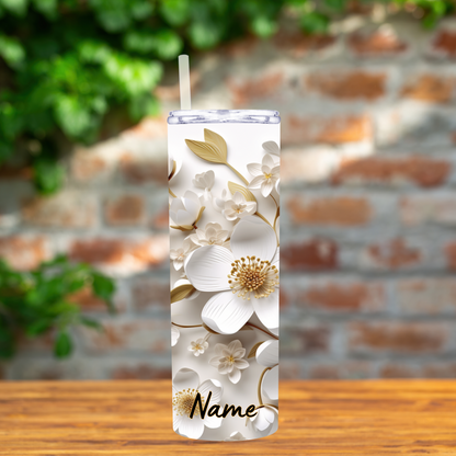 Tumbler with floral design and 'Name' text on a wooden surface with a blurred brick wall background