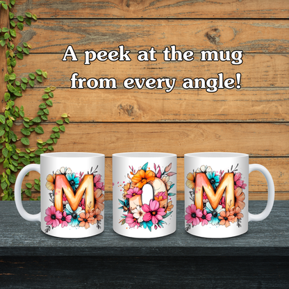 Three mugs with floral designs and letters 'M' and 'O' on a wooden background.