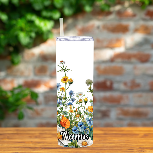 Tumbler with floral design and 'Name' text on a wooden surface with a brick wall background