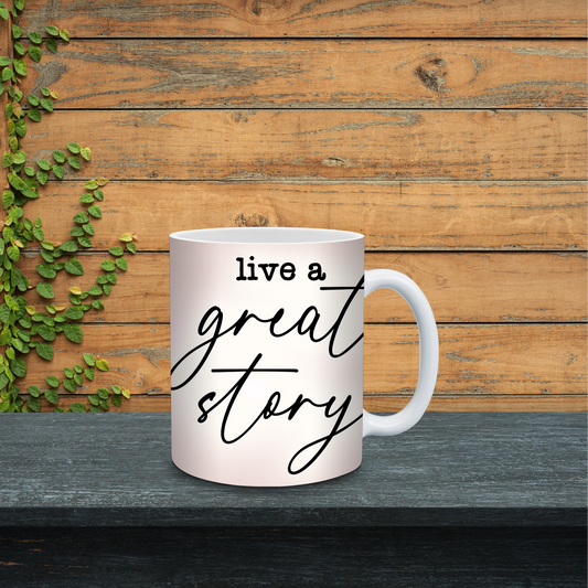 White mug with 'live a great story' text on a wooden surface with greenery.