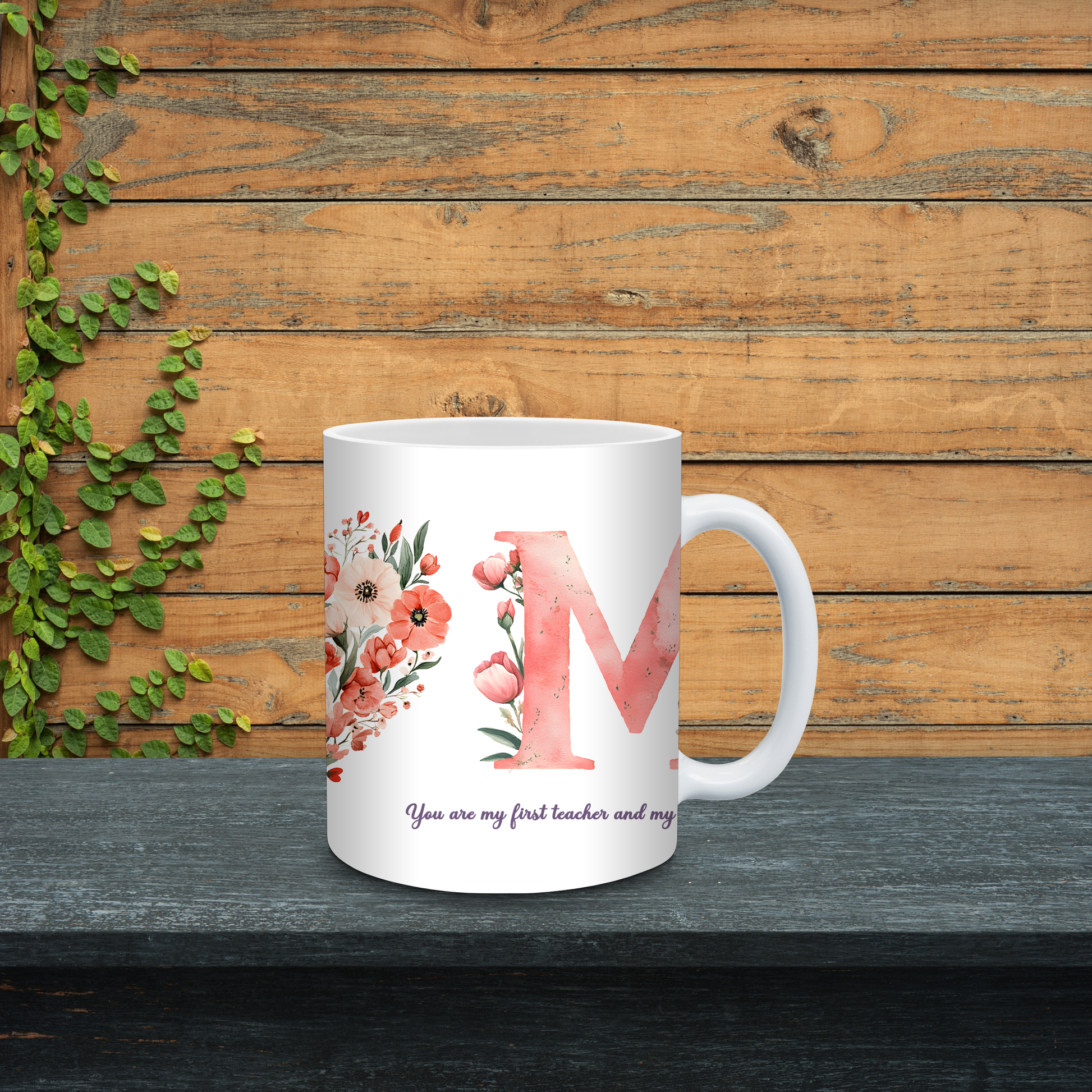 White mug with floral design and letter 'M' on a wooden background
