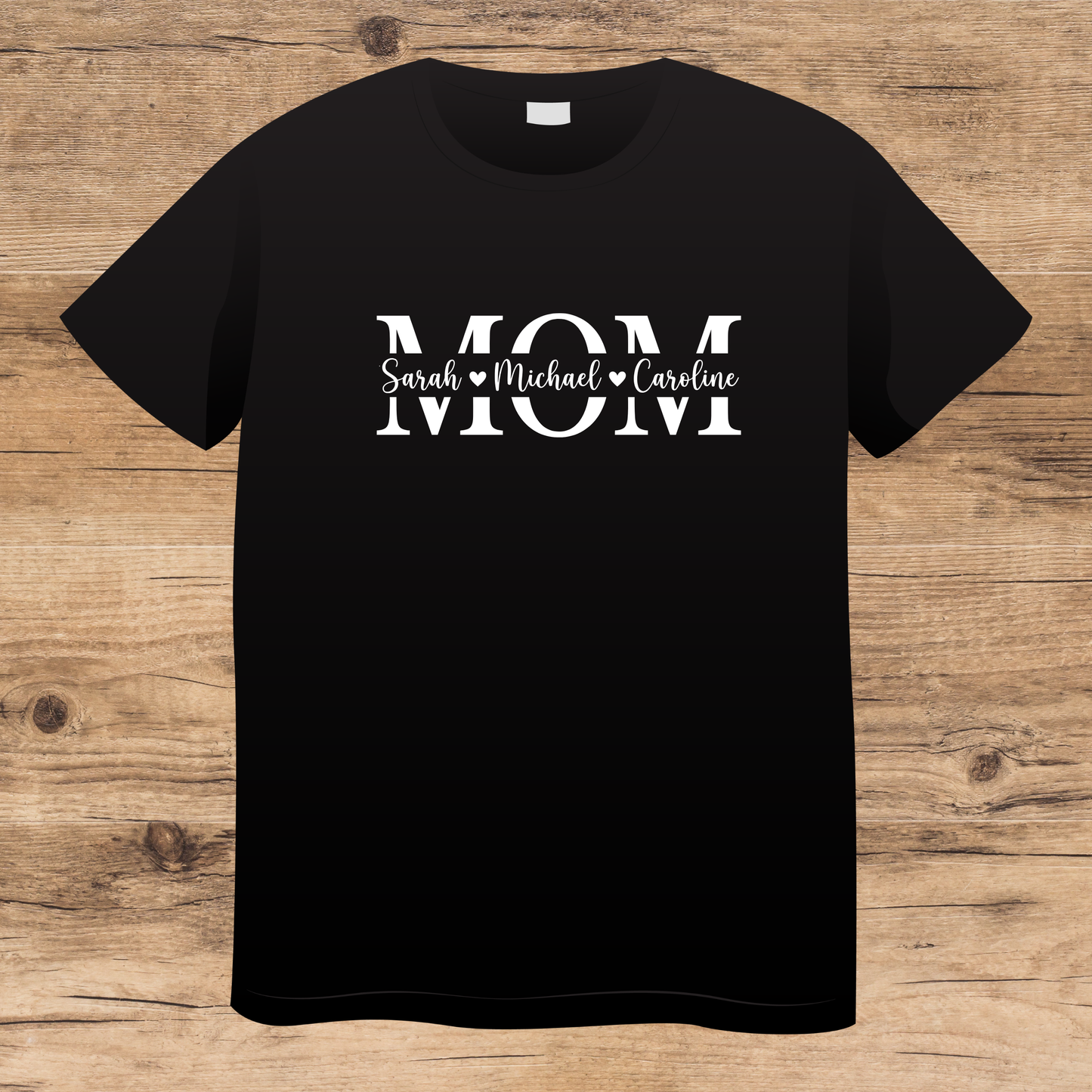 Black t-shirt with 'MOM' text on a wooden surface