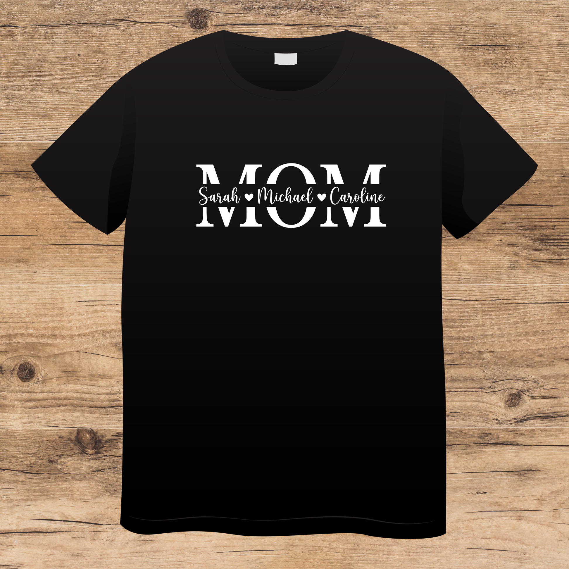 Black t-shirt with 'MOM' text on a wooden surface