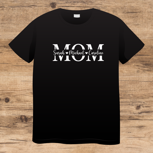Black t-shirt with 'MOM' text on a wooden surface