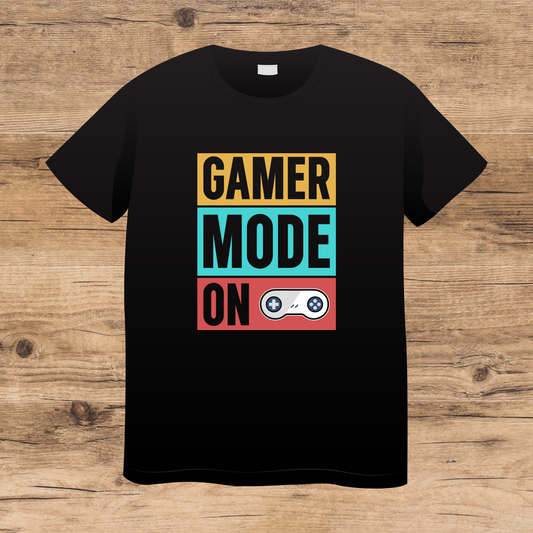 Black t-shirt with 'Gamer Mode On' text and graphics on a wooden surface