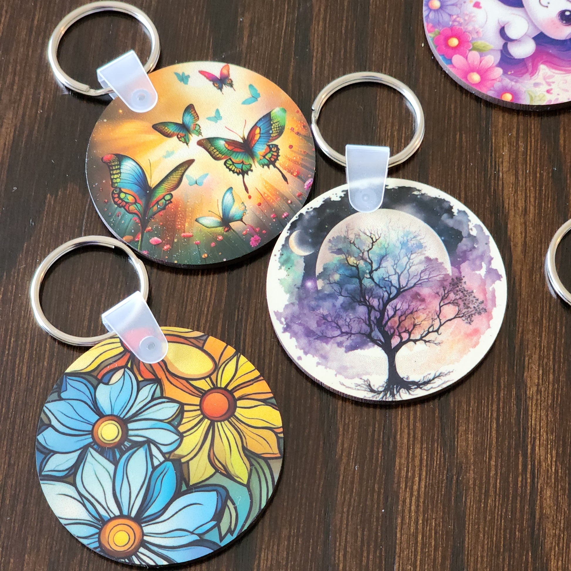 Colorful keychains with artistic designs on a wooden surface