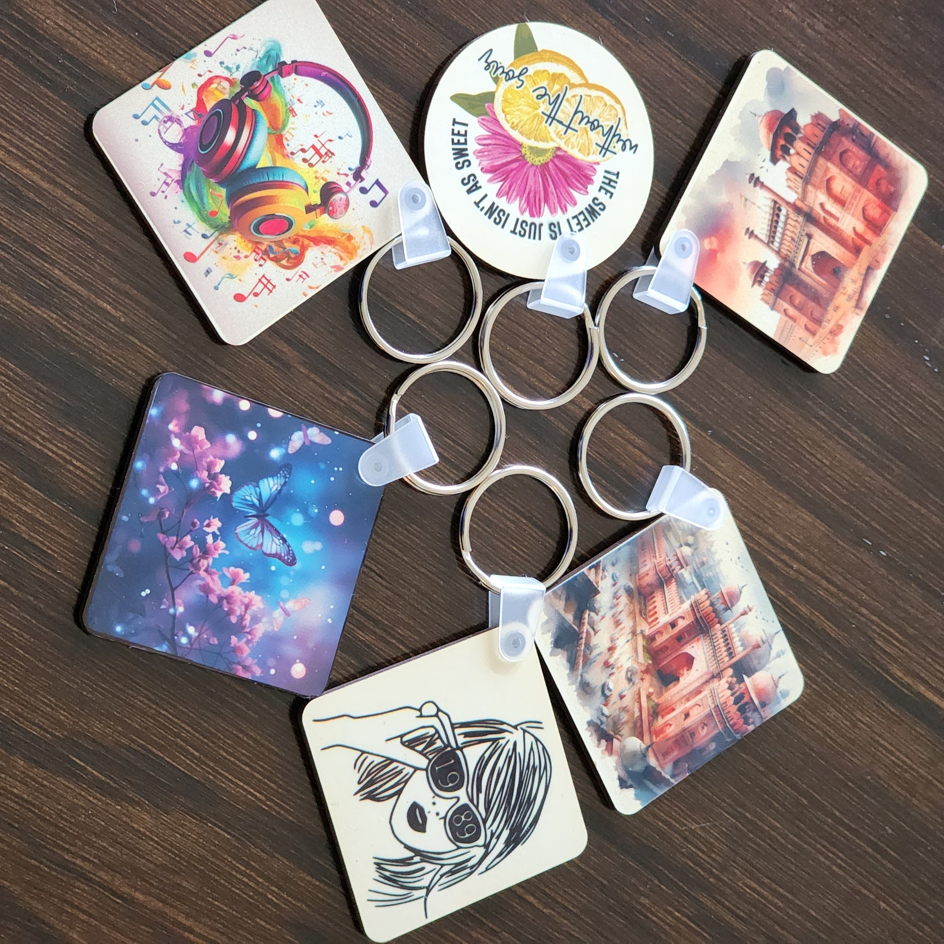 Set of keychains with colorful designs on a wooden surface