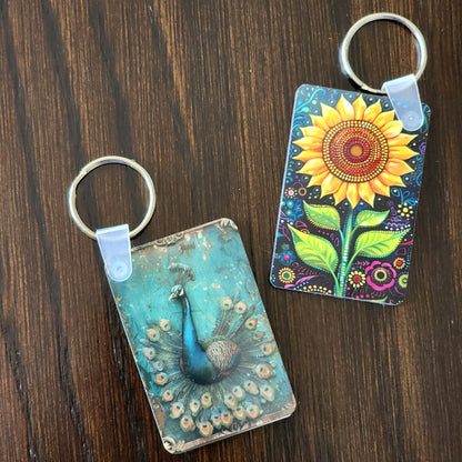 Two keychains with artistic designs on a wooden surface