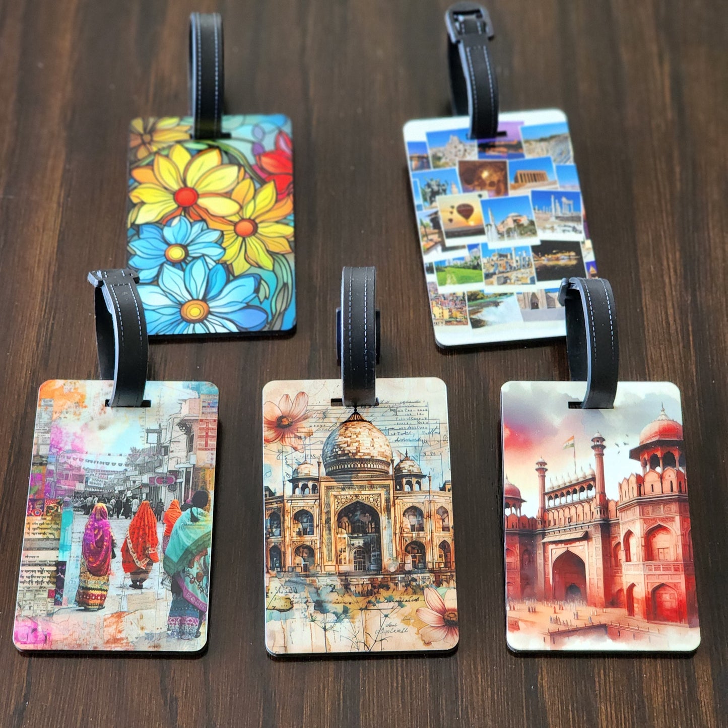 Five colorful luggage tags with various designs on a wooden surface