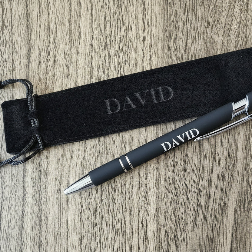 Black pen with gold accents and 'DAVID' engraving on a wooden surface