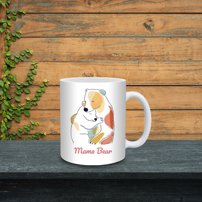White mug with 'Mama Bear' design on a wooden surface with greenery