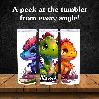Three colorful tumbler designs with cartoon dinosaurs on a wooden surface and dark background.