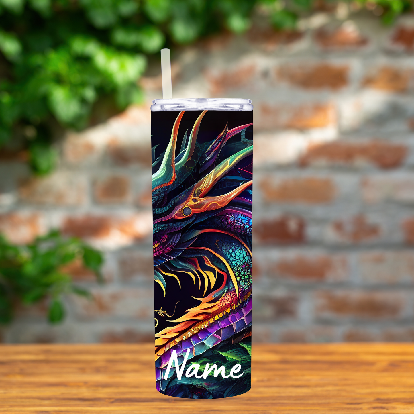 Colorful dragon design tumbler with straw on a wooden surface and brick wall background