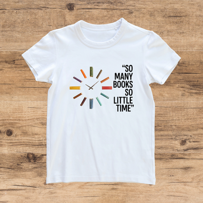 White t-shirt with book-themed design and text on a wooden surface