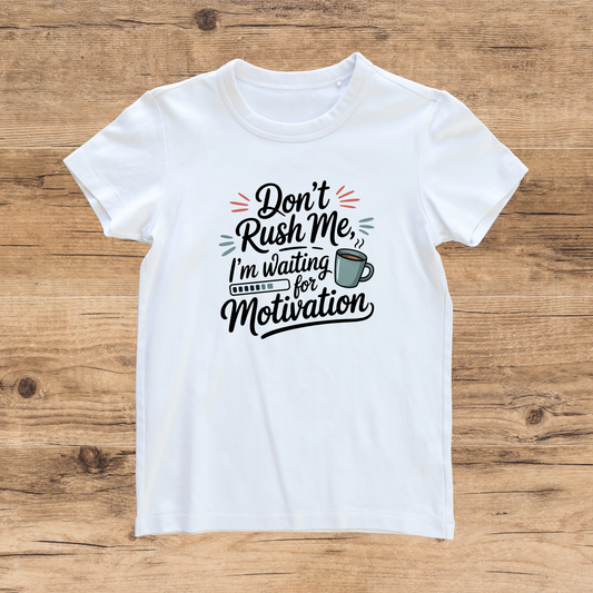 White t-shirt with humorous text design on a wooden surface