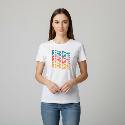 White t-shirt with 'RECREATE' text in colorful letters on a wooden surface