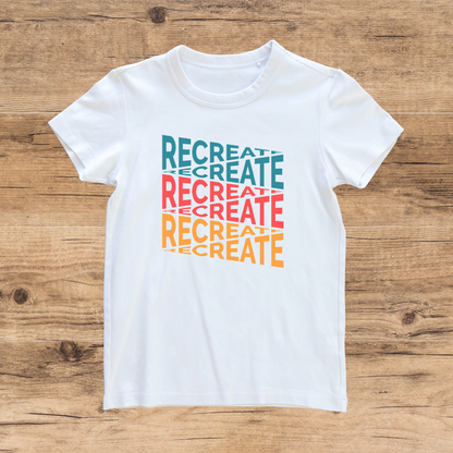 White t-shirt with 'RECREATE' text in colorful letters on a wooden surface
