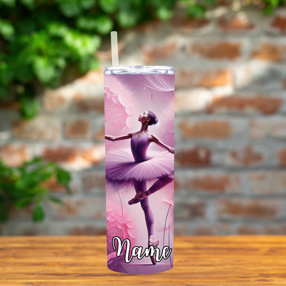 Tumbler with a ballerina design on a wooden surface with a brick wall background
