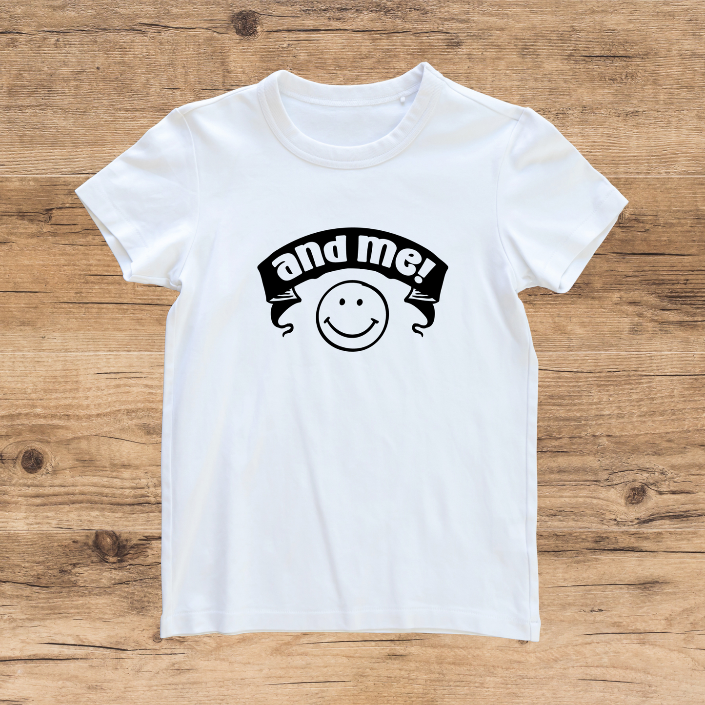 White t-shirt with a black graphic design on a wooden surface