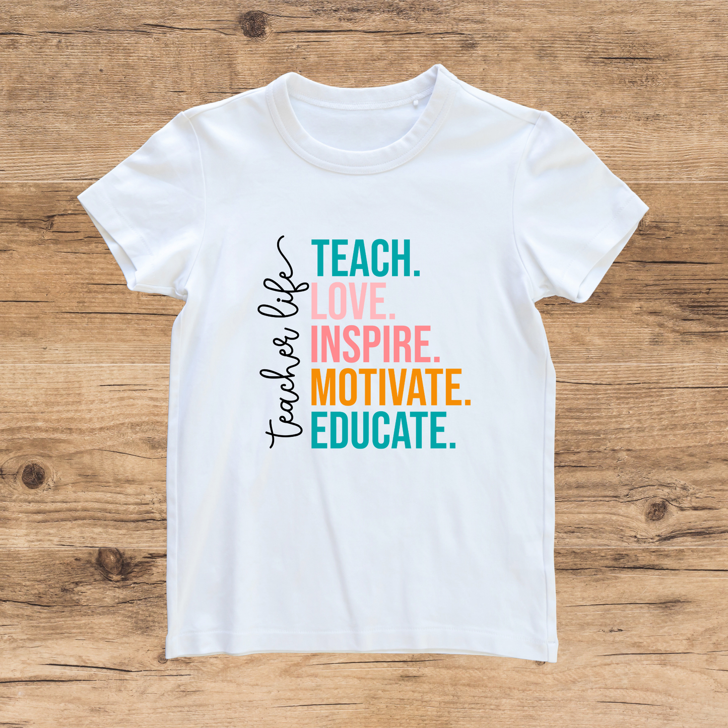 White t-shirt with colorful text on a wooden surface