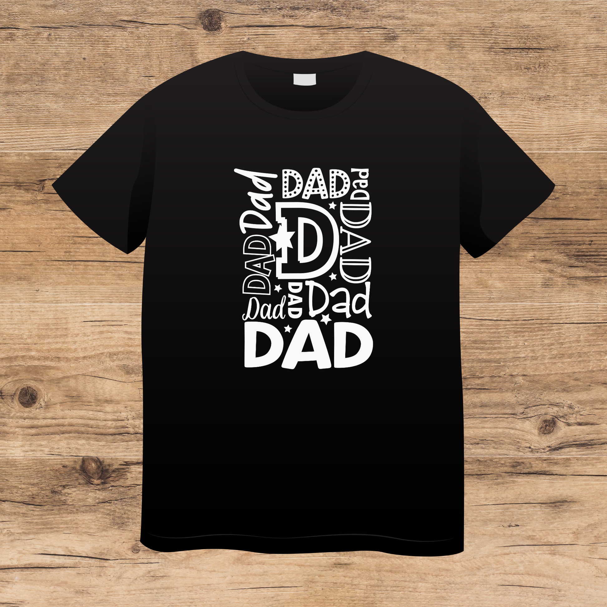 Black t-shirt with 'DAD' text design on a wooden surface