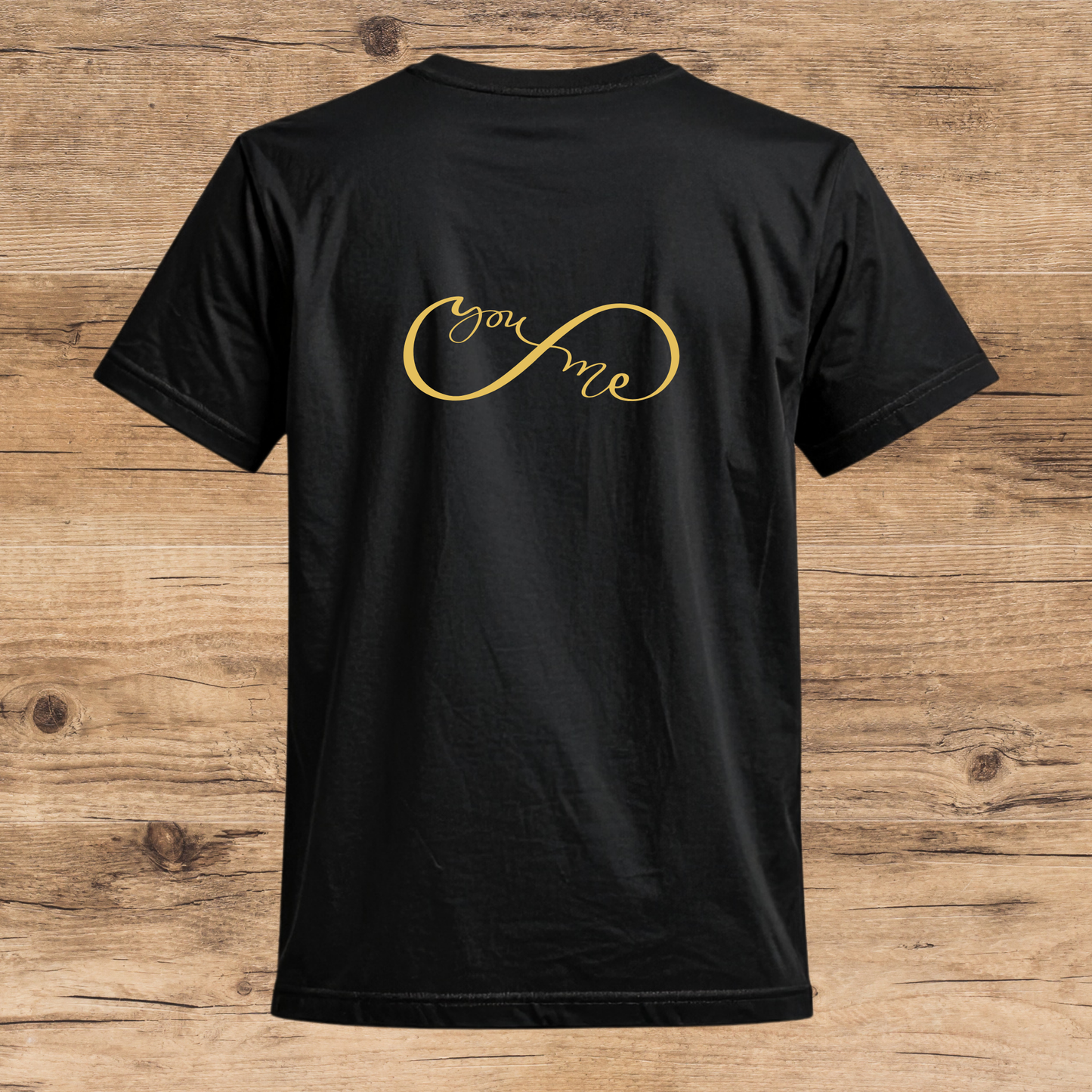 Black t-shirt with 'you & me' in gold on a wooden surface