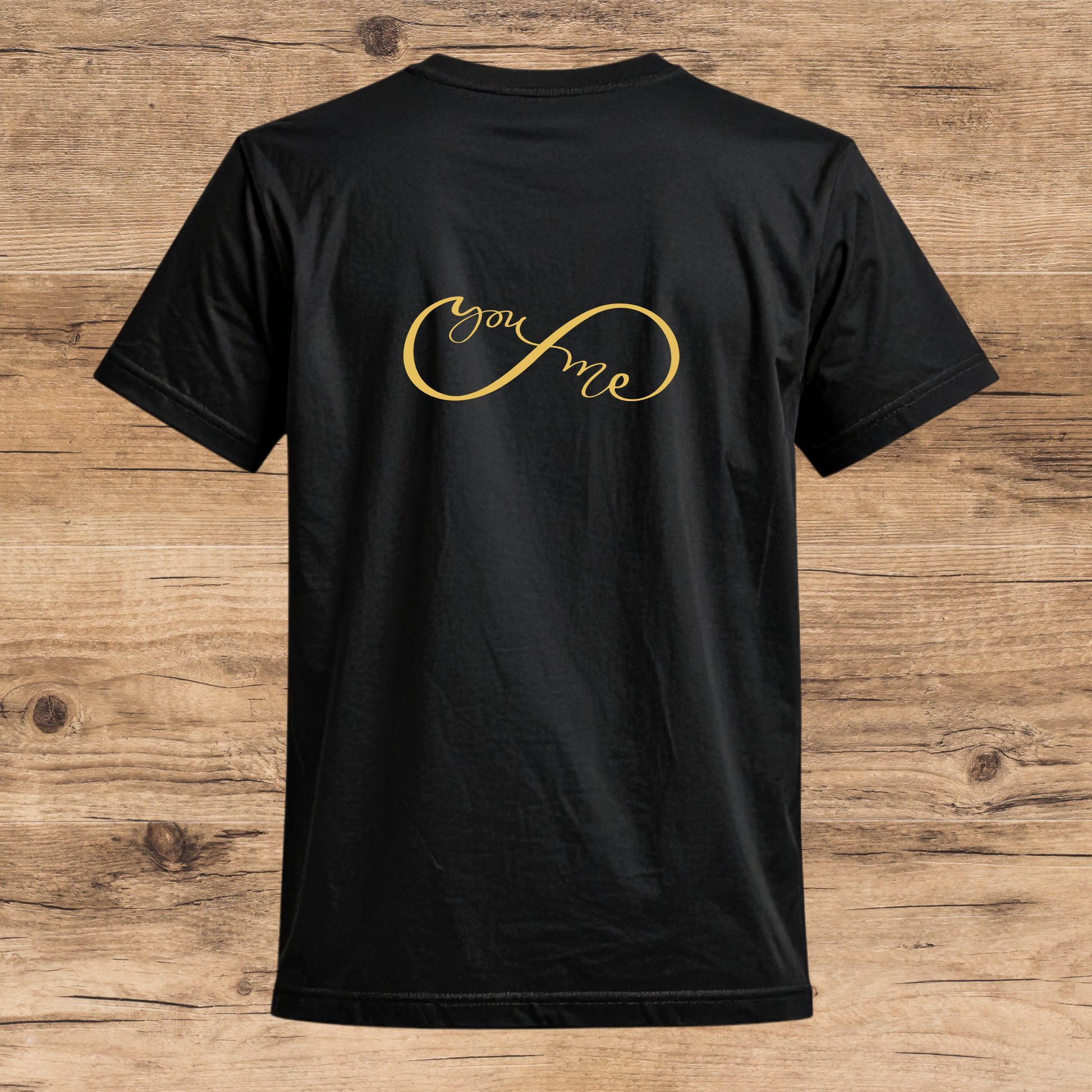 Black t-shirt with 'you & me' in gold on a wooden surface