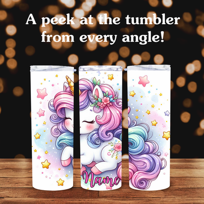 Three colorful tumblers with unicorn designs on a wooden surface and blurred lights background.
