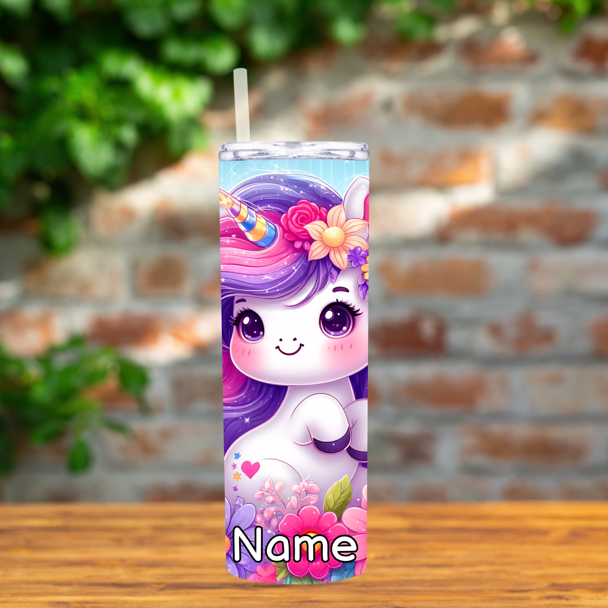 Tumbler with a unicorn design on a wooden surface with a brick wall background