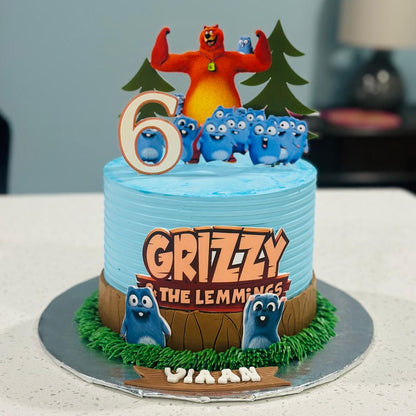 Birthday cake with cartoon characters and 'Grizzly the Lemmings' branding on a neutral background
