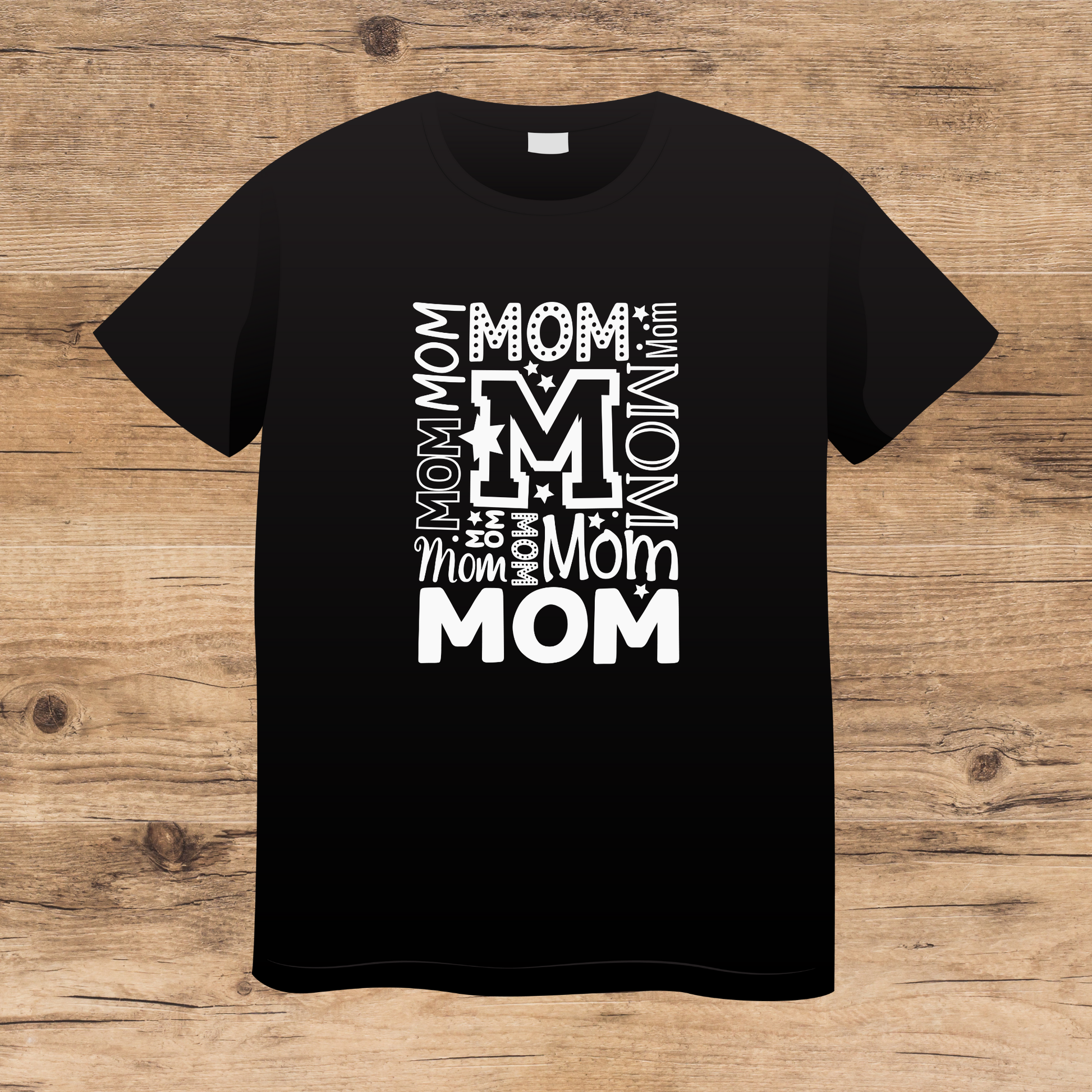 Black t-shirt with white 'Mom' text design on a wooden surface