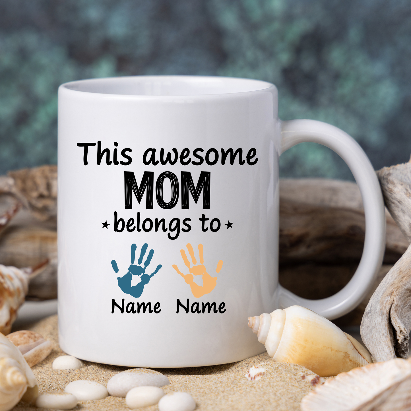 White mug with text and hand print designs on a beach setting