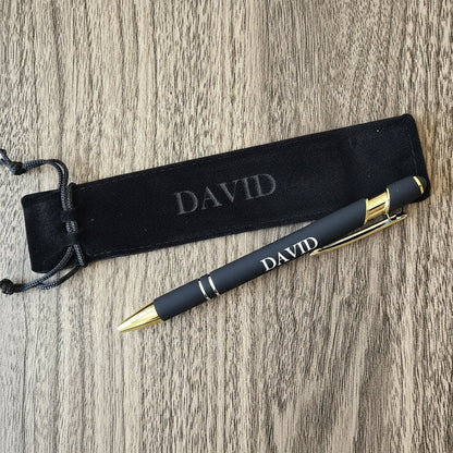 Black pen with gold accents and 'DAVID' engraving on a wooden surface