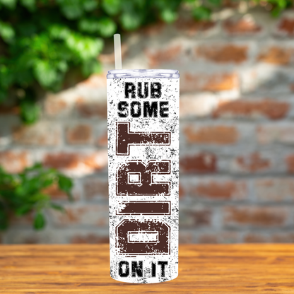 Tumbler with 'Rub Some dirt On It' text on a wooden surface with a blurred brick wall background