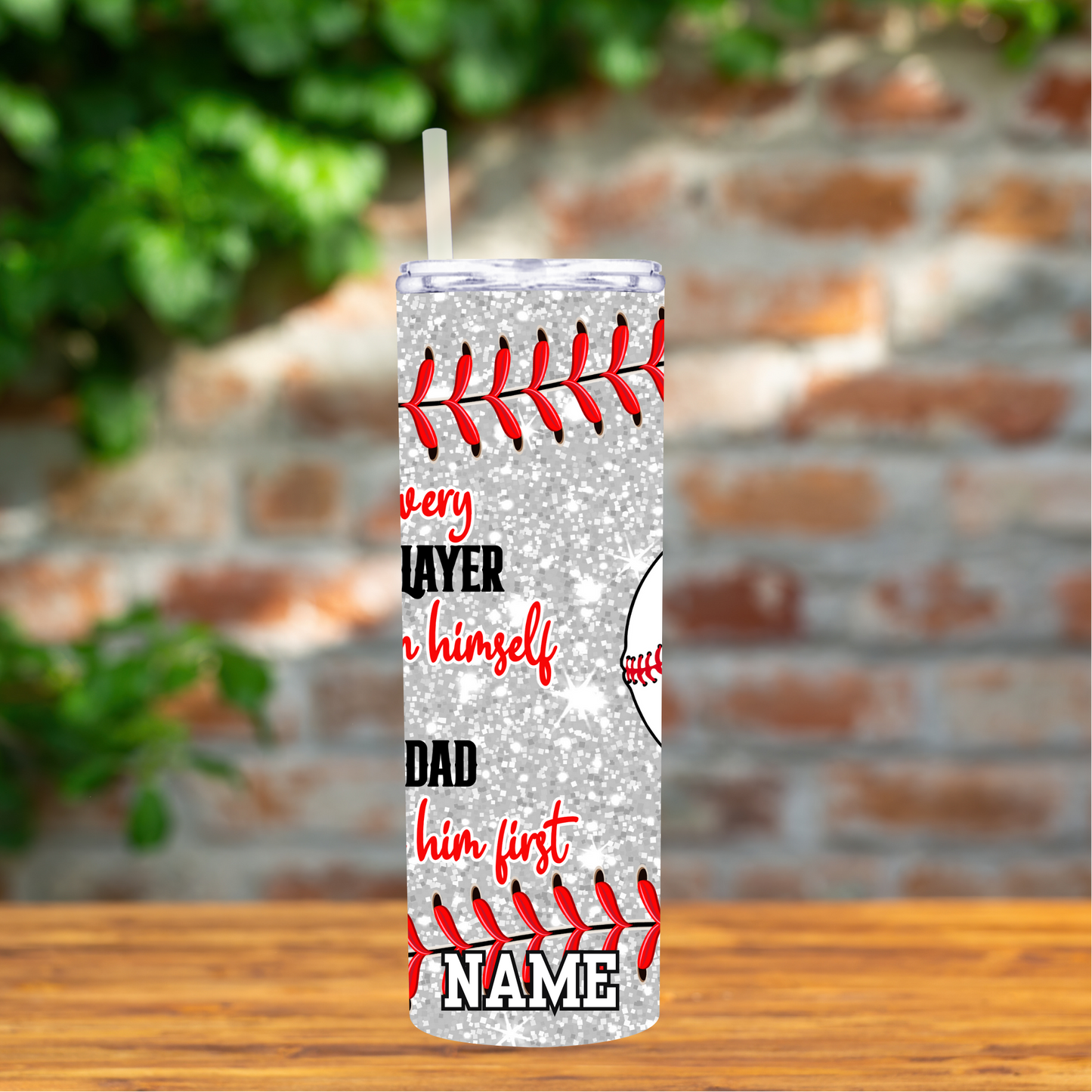 Tumbler with baseball design and text on a wooden surface with a blurred brick wall background