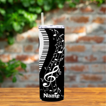 Tumbler with musical design and 'Name' text on a wooden surface with a brick wall background