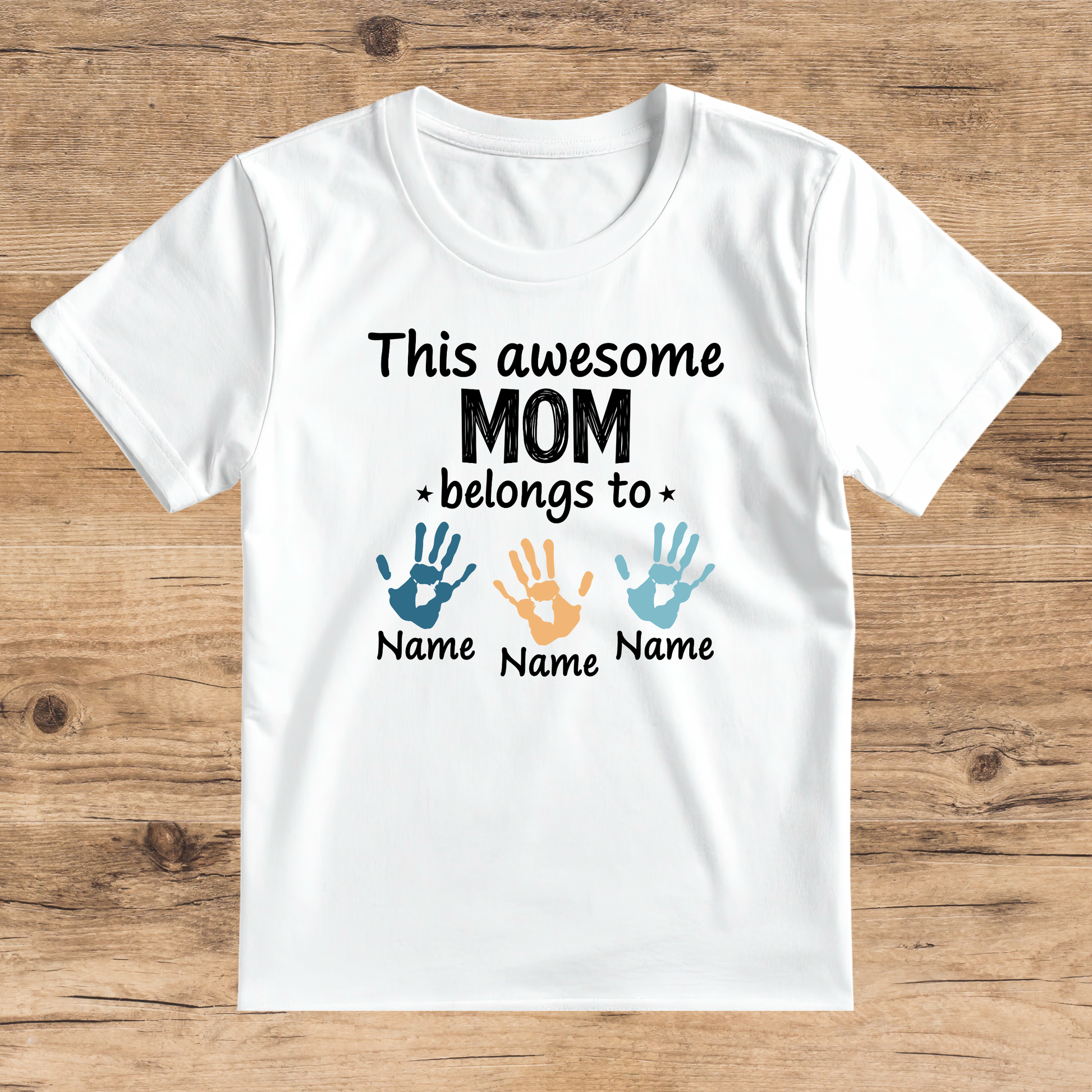 White t-shirt with text and hand print graphics on a wooden surface