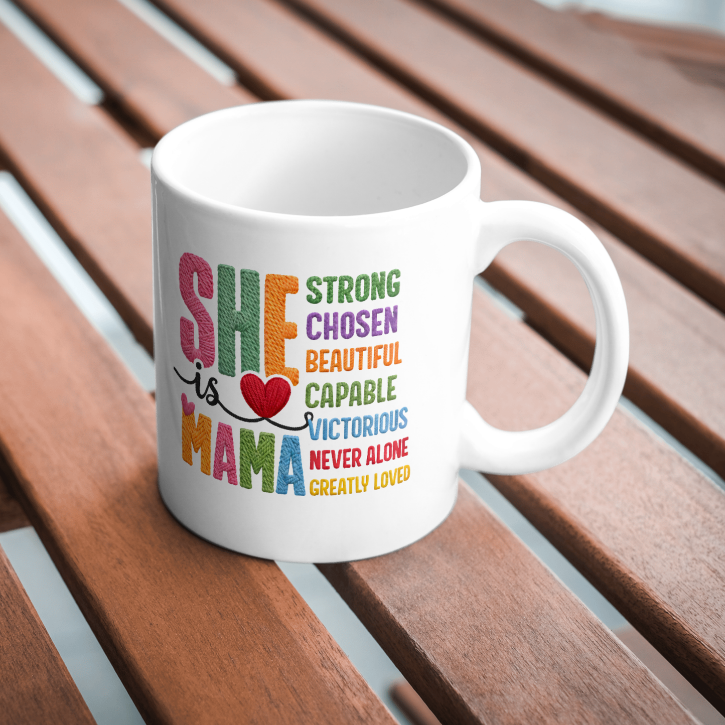 White mug with colorful text on a wooden surface