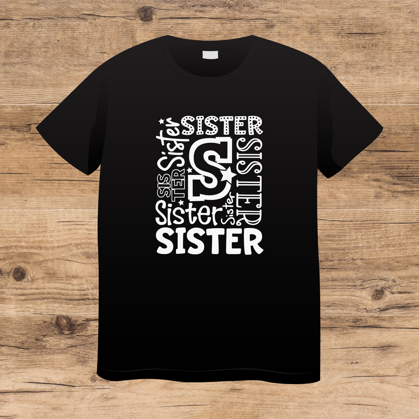 Black t-shirt with 'SISTER' text design on a wooden surface