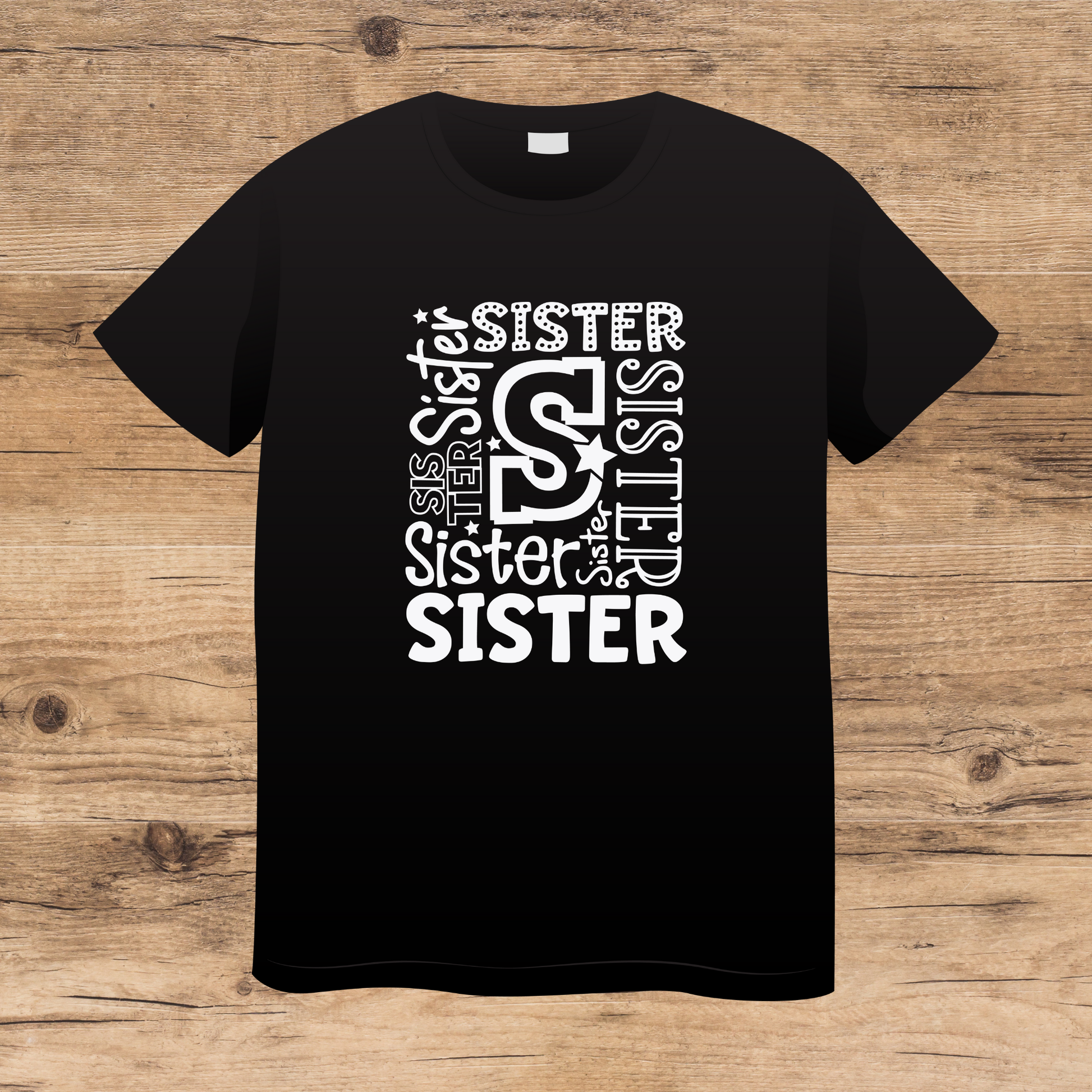 Black t-shirt with 'SISTER' text design on a wooden surface