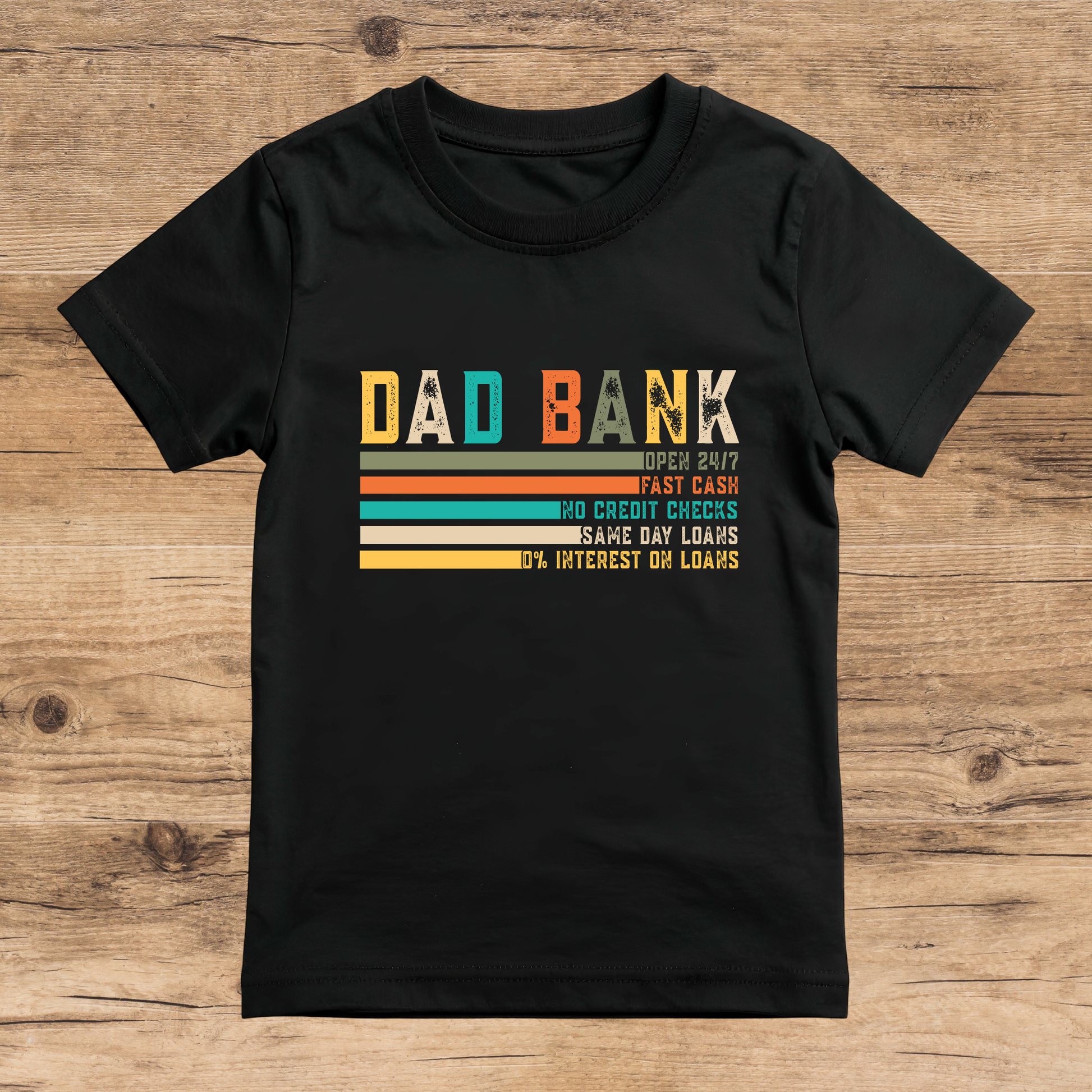 Black t-shirt with colorful text design on a wooden surface