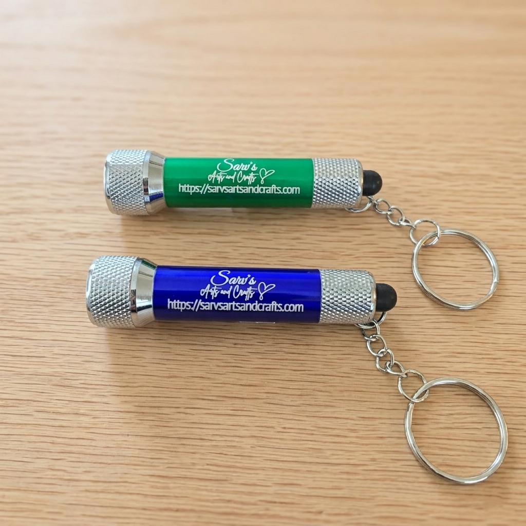 Two keychains, one green and one blue, on a wooden surface.
