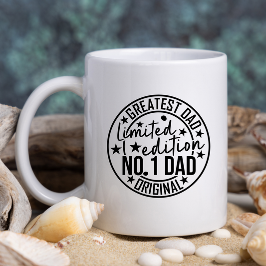 White mug with 'Greatest Dad Limited Edition No. 1 Dad Original' text surrounded by shells and sand.