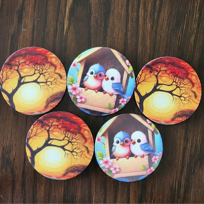 Set of five round coasters with nature and bird designs on a wooden surface