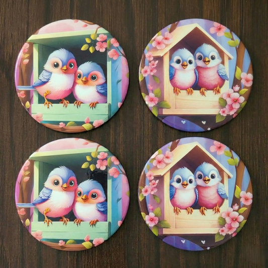 Four colorful coasters with cartoon birds and a birdhouse on a wooden surface.