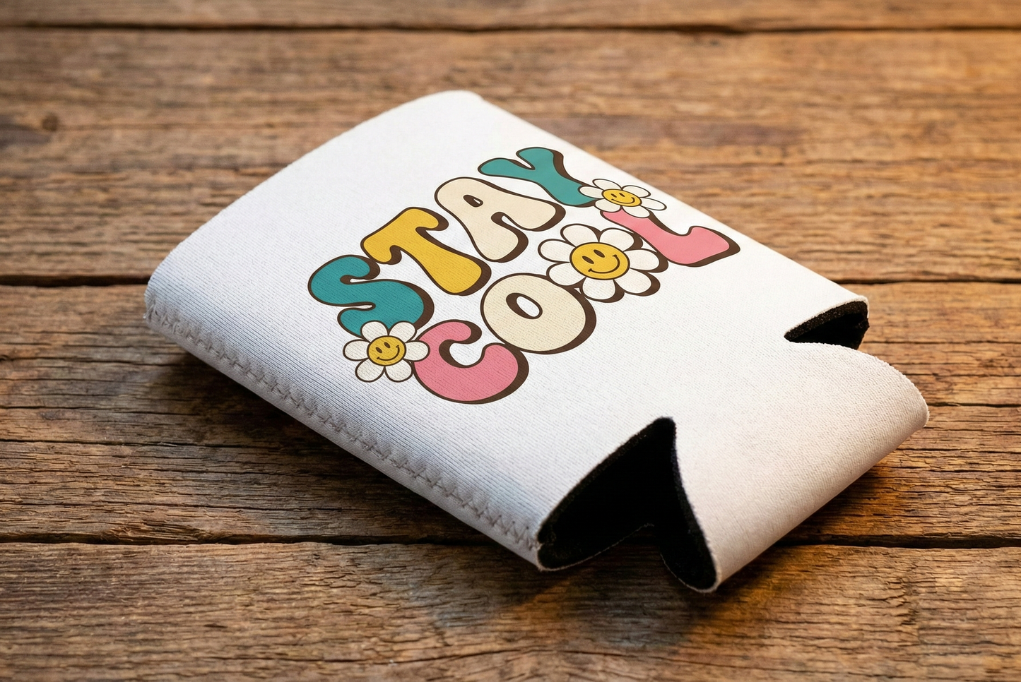 Can cooler with 'Stay Cool' text and flowers on a wooden surface