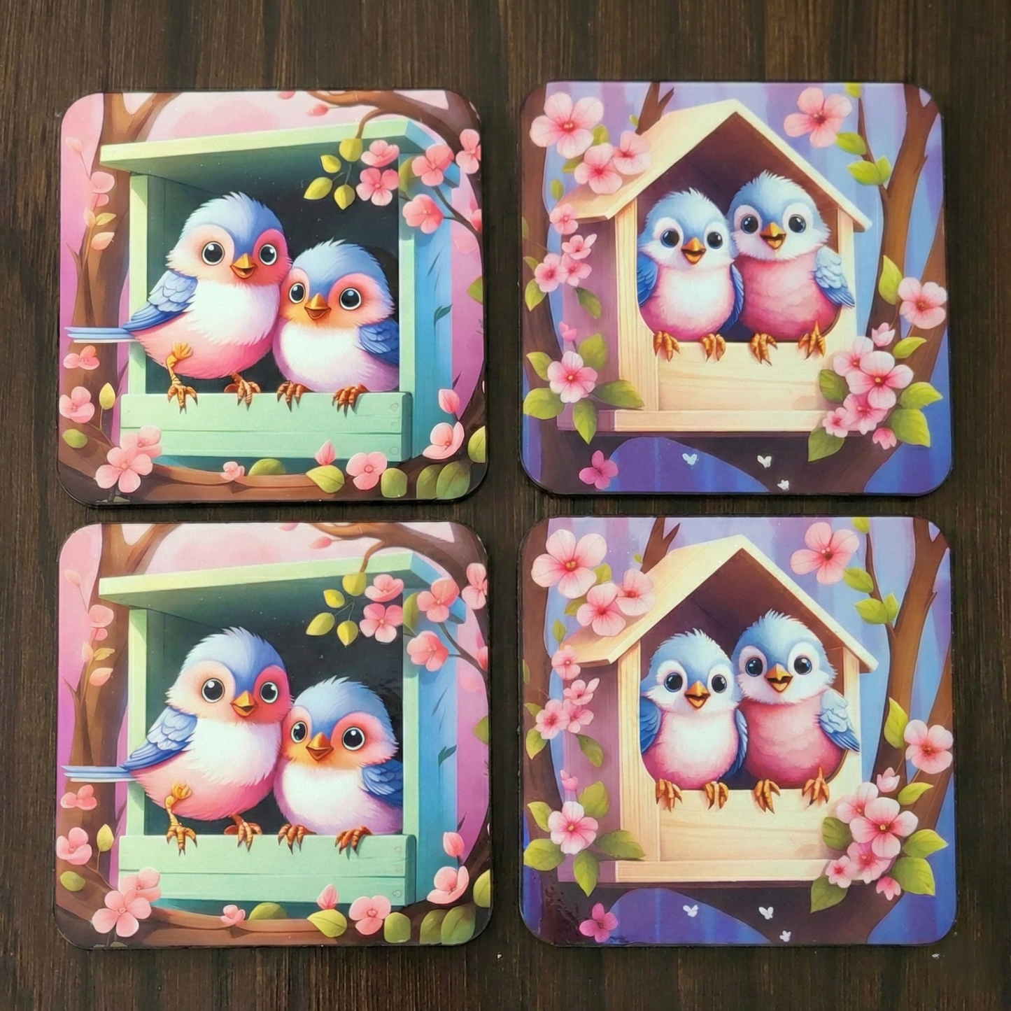 Four colorful coasters with cartoon birds and a birdhouse on a wooden surface.