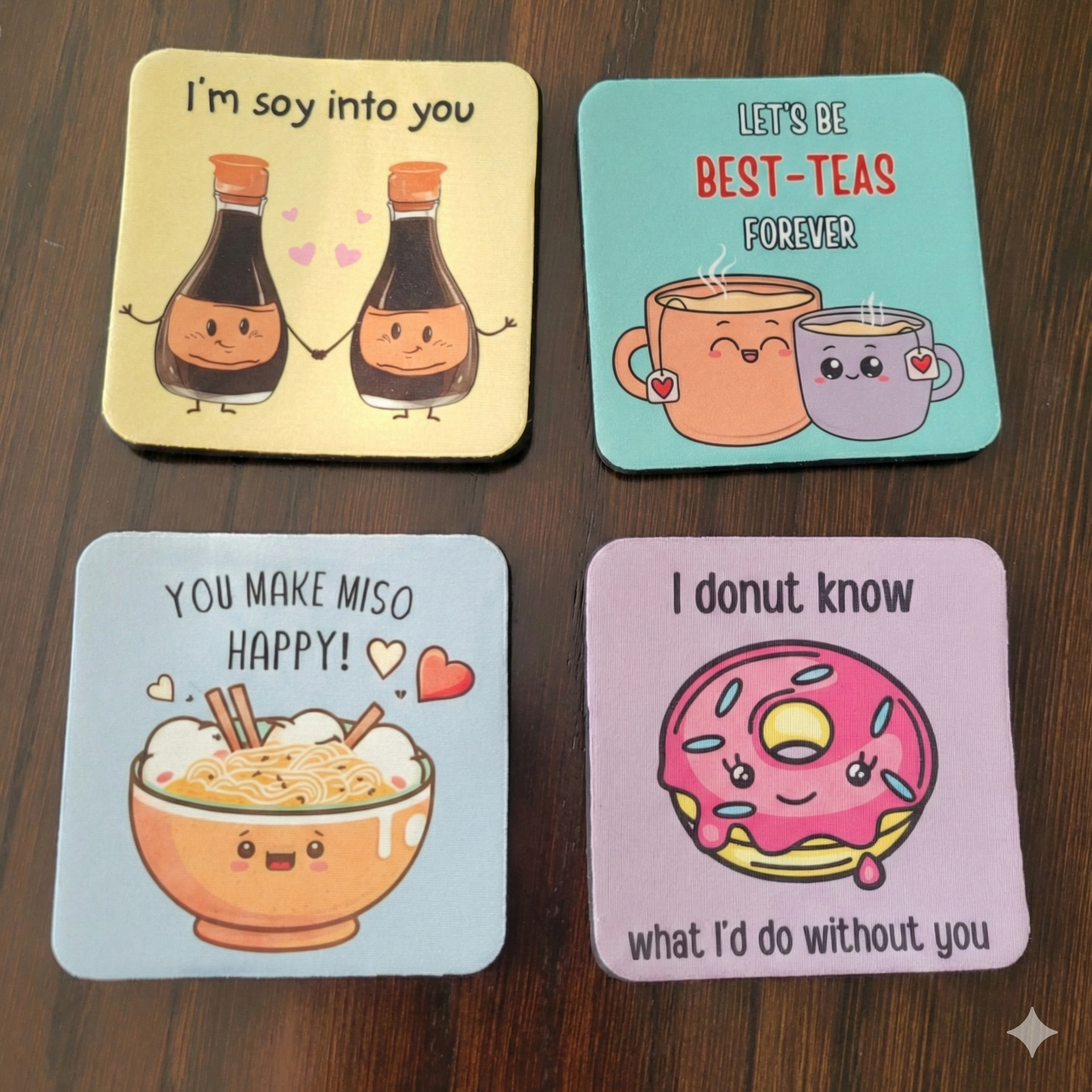 Four colorful coasters with cartoon designs on a wooden surface